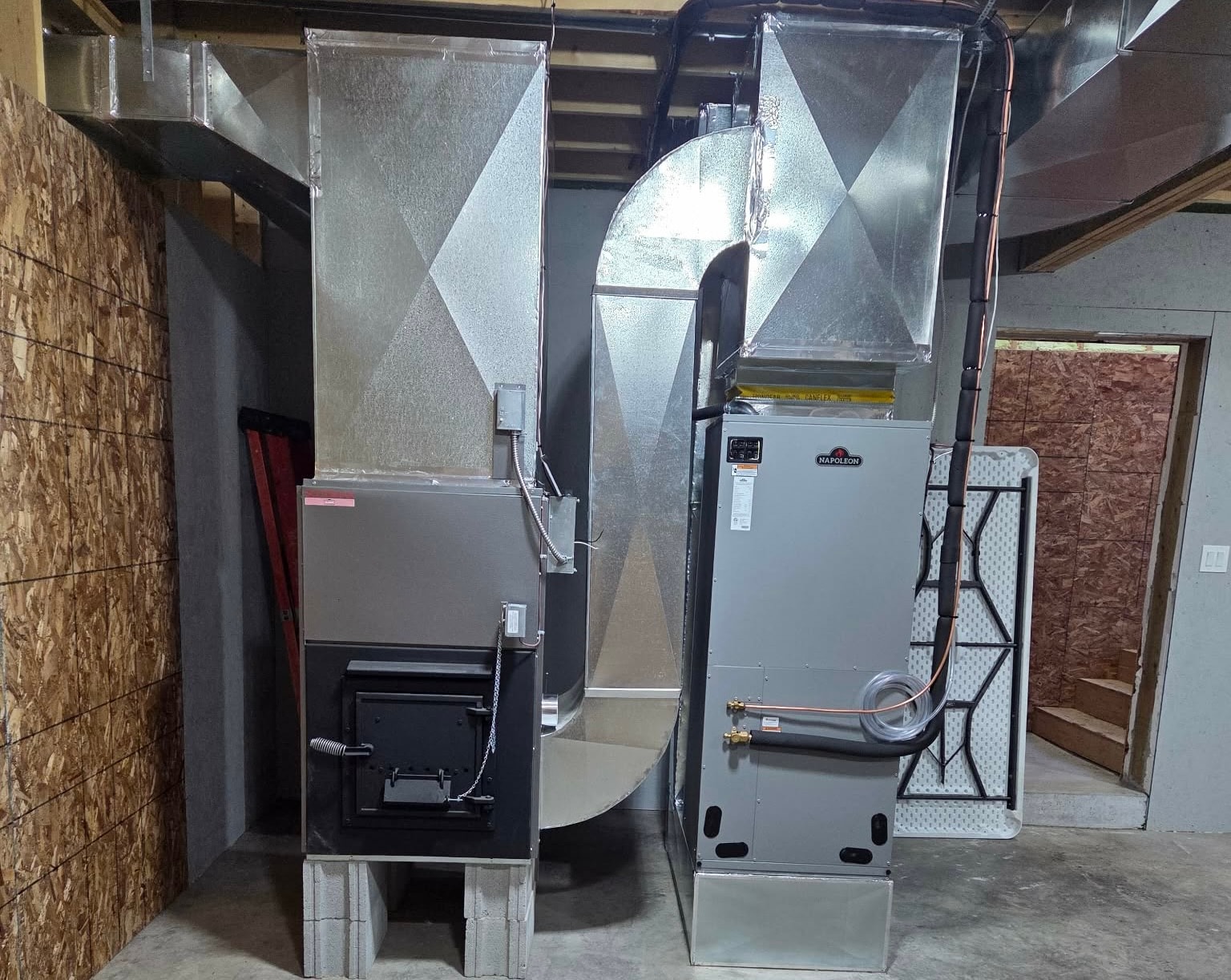 Napoleon air handler and wood furnace with custom sheet metal ductwork in basement